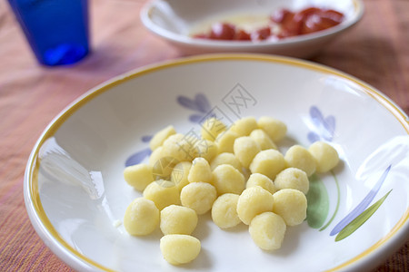 有新鲜西红柿的马铃薯小燕子土豆盘子衣服汤团白色饺子图片