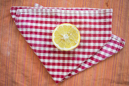 柠檬在彩色餐巾纸上切半餐巾水果黄色果汁背景图片
