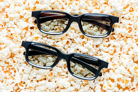 两副 3D 眼镜特写放在盐渍爆米花上图片