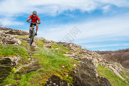 红夹克骑马山下落基山 极端运动和冒险概念的赛车手娱乐自行车锻炼男人竞赛蓝色男性天空速度活动图片