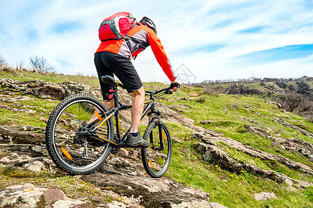 红夹克骑马山下落基山 极端运动和冒险概念的赛车手骑士锻炼旅行行动男性爬坡天空车轮男人娱乐图片