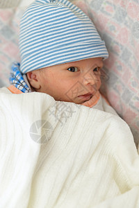 身戴帽子的新生儿男婴苏醒蓝色毯子男生眼睛生活孩子儿子新生皮肤图片