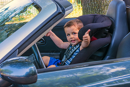 坐在汽车儿童座位上的儿童喜悦座椅交通孩子们敞篷车安全运输表情车辆措施图片