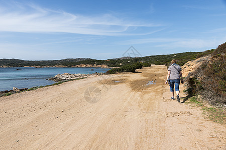 在卡特雷拉岛上行走的妇女热带山脉石头旅行蓝色海岸线岩石冒险晴天天堂图片