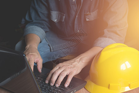 使用膝上型计算机操作黄头盔的建筑工程师a建设者安全帽工作建筑师企业家工具监视器衣领技术成人图片