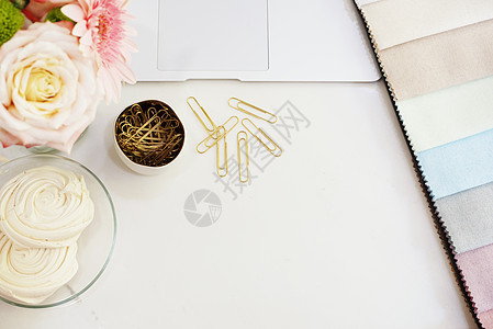 桌上的织物样品 设计师的工作场所概念 自由时尚舒适的女性气质工作区 平躺风格 白色大理石背景上有鲜花 顶视图 明亮 粉红色和金色图片