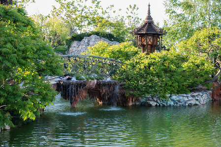 在绿公园的湖上有美丽的桥 美丽的池塘和脚桥环绕着树木和鲜花花朵反射旅行童话公园城堡天空花园行人石头图片