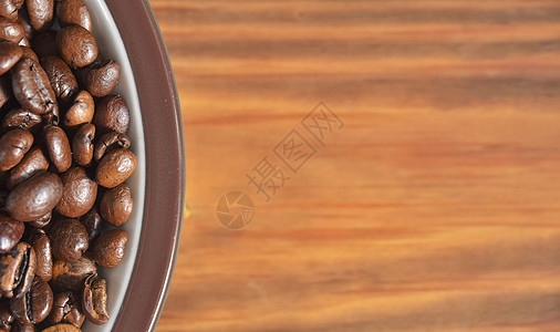 在木制背景上 旁边是油炸咖啡豆的碟子图片