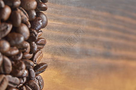许多咖啡豆位于木质背景的左侧图片