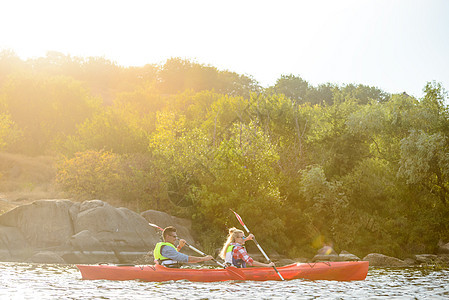 年轻快乐的情侣在美丽的河流或湖上男人活动闲暇娱乐冒险日落男性女士海浪划桨图片