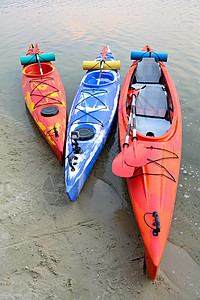 三人在美丽河附近沙滩或夜晚的湖边旅行Kayaks 旅行和冒险概念 笑声活动蓝色旅游娱乐闲暇探索运动海岸游览游客图片