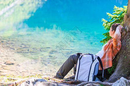 女人用背包放松 和休息在湖边 在山上图片