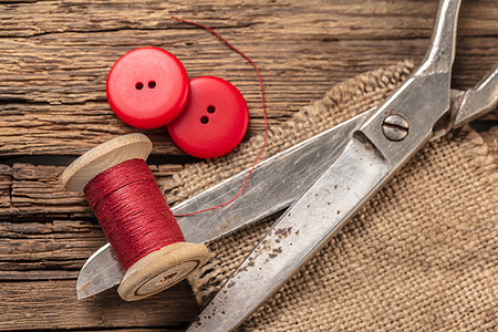 带纽扣和剪刀的红线织物针线活工艺工作筒管棉布裁缝维修卷轴衣服图片