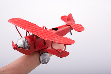 手持白色背景的玩具飞机Name航班旅行世界车辆运输商业乘客喷射航空公司背景图片