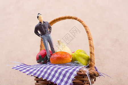 一个带塑料水果的篮子上的小人雕像团体高架食物收成小吃季节李子饮食柠檬男人图片