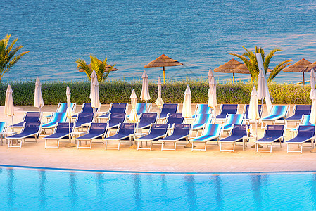 美丽的豪华户外游泳池 配有雨伞和椅子温泉假期季节棕榈太阳泳池蓝色热带海滩情调图片