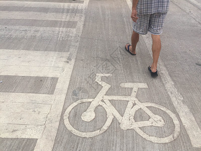 男子在自行车路标志附近行走图片