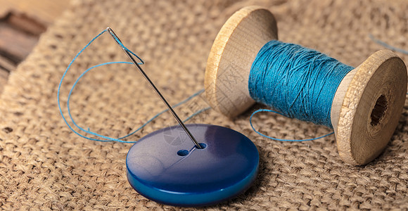 有needl的蓝色按钮衣服桌子裁缝木头爱好纽扣材料维修针线活工作图片