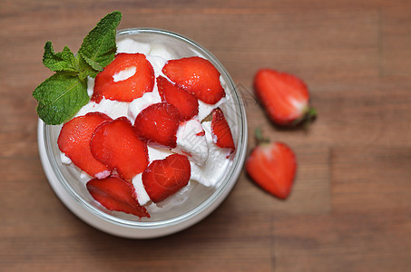 餐桌上有切片草莓的香草冰淇淋图片
