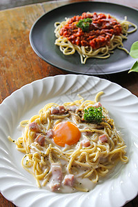 意粉 Carbonara 蛋黄和意粉意大利面 wi盘子桌子餐厅猪肉午餐红色面条食物火腿白色图片