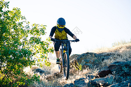 赛车手骑着山上摩托 在夏日落石轨的夜晚 极端运动和Enduro自行车概念踪迹男人爬坡车轮护目镜活动下坡岩石山地车眼镜图片