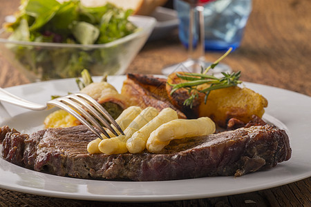 白白牛排和叉子牛肉盘子蓝色沙拉红色肋骨迷迭香食物蔬菜烧烤图片