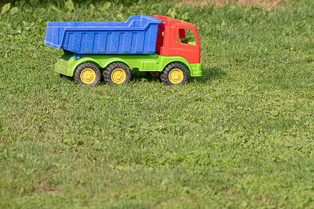 草地上的玩具卡车 废弃玩具机器乐趣橙子场地树干商业童年孩子塑料汽车图片