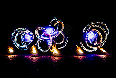 火光闪耀的烈火碎片火炬舞蹈家旋转危险运动男人舞蹈展示漩涡节日图片