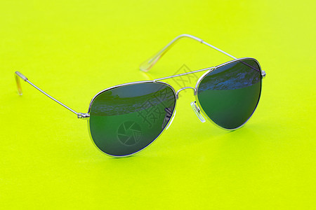 绿色背景的现代时尚太阳镜图像 格拉斯黑色反射眼睛光泽度塑料乐趣紫外线蓝色太阳光学图片
