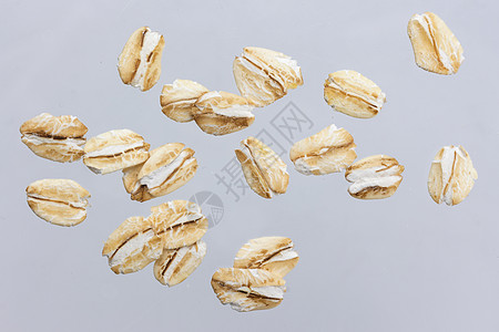 在白色背景上隔离的Oat片段 特写粮食早餐收藏薄片种子谷物稀饭燕麦宏观飞行背景图片