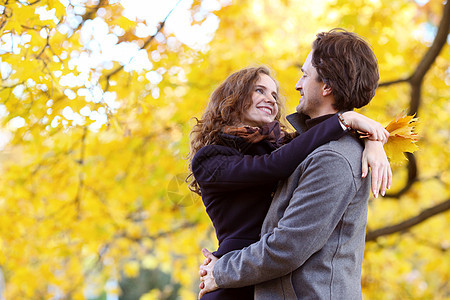 在秋天公园拥抱一对微笑的情侣家庭季节男人女士男朋友女朋友闲暇幸福公园黄色图片