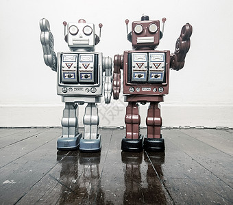 两个老式机器人在木地板上打招呼图片