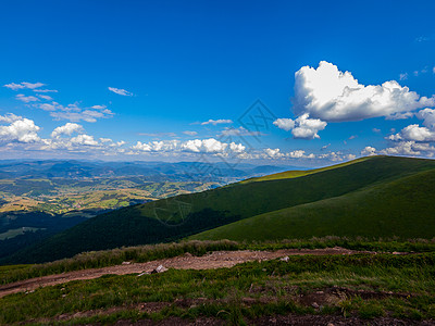 蓝色天空中的白云飘浮在山峰上 延展到地平线处图片