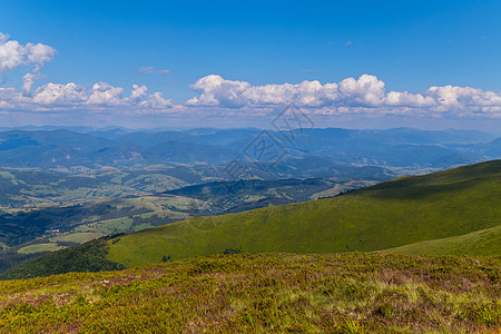 蓝云下地平线外的绿色山岳图片