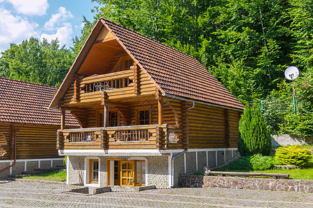 具有宽阔的全景凉台和一块砖瓦屋顶的可舒适的木制三层三层楼小别墅背景图片