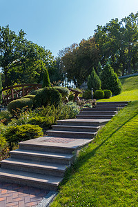 公园的台阶都布满了在山丘上用绿草坪 一面铺着一块瓷砖 另一边想着灌木丛图片
