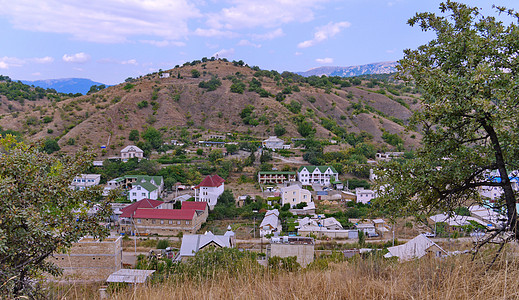 远山背景下岩石山脚下朴实无华的小镇图片