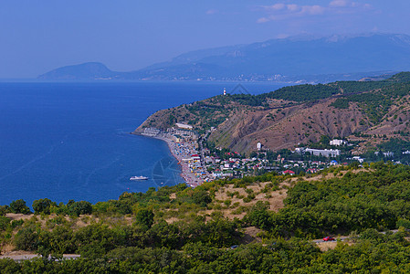 一望无际的蓝色大海 在高山的映衬下冲刷着一座大型度假城市的海岸图片