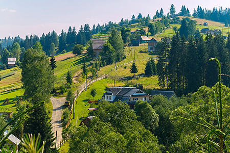 山坡上挂有房屋和沿着围栏行走的道路的闪光山坡图片