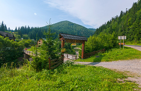 通往度假旅馆建筑群的木制门入口处的公路;图片