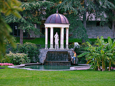 装饰喷泉 在公园区背景上雕塑一名女性和白色柱子的雕塑图片