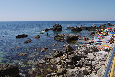 观光客 躺在海滩上 旁边的巨石堆 远到大海图片