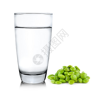 白色背景的玻璃杯水和大豆图片