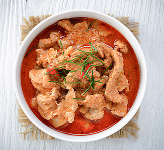 Panang咖哩加猪肉树叶烹饪椰子美食午餐绿色辣椒牛奶红色食物图片