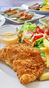 桌边有满食物土豆午餐鳕鱼海鲜健康蔬菜绿色牛扒白色薯条图片
