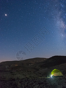 在沙漠度假时在恒星下安居乳白色山脉银河系天文学远足星星游客旅行帐篷假期图片