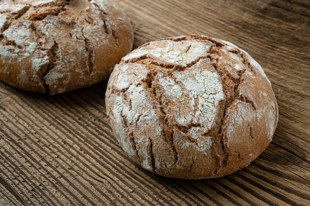 新鲜烤熟的面包 在旧木制桌子上食物棕色木头脆皮饮食木板早餐乡村美食面粉图片