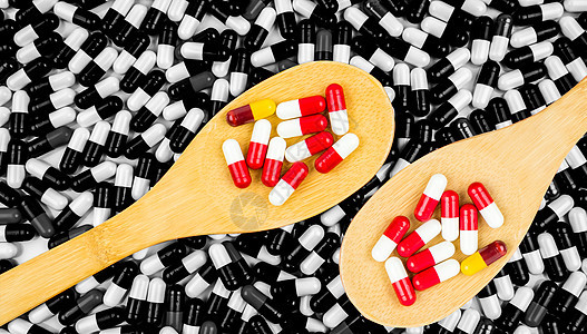 五颜六色的抗生素胶囊药丸在木勺黑白背景的胶囊 耐药性概念 抗生素用药具有合理的全球保健理念 医药行业 药房背景图片
