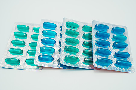 蓝色胶囊蓝色和绿色软胶囊药丸 装在白色底片的烟雾包中;止痛药;制药业;药剂产品背景