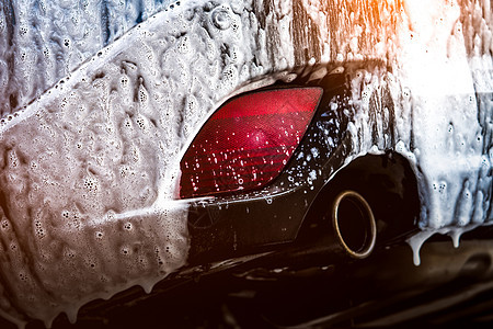 具有运动和现代设计的蓝色紧凑型 SUV 汽车用肥皂洗涤 用白色泡沫盖的汽车 汽车护理服务经营理念 玻璃打蜡和玻璃涂层汽车前用泡沫图片